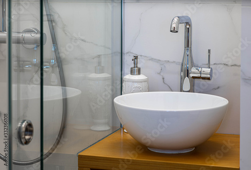 Fototapeta Naklejka Na Ścianę i Meble -  White sink in modern contemporary bathroom. Marble tile on the wall. Close-up.