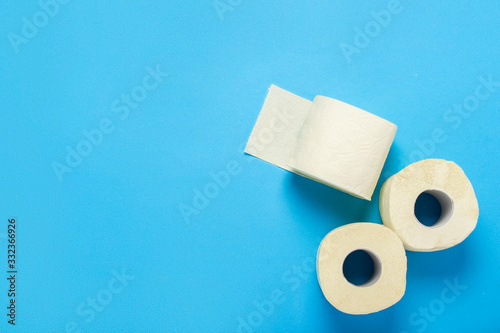 toilet paper rolls on a blue background. Flat lay, top view. Hygiene concept, deficiency, quarantine. Banner.