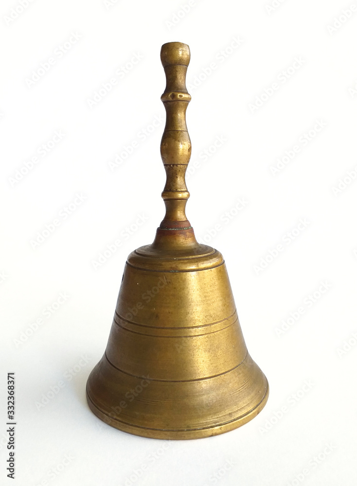 Old golden brass musical bell isolated on white background. Close-up of user-friendly metal hand bell.