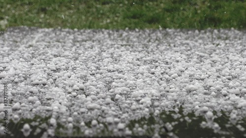 Falling hail on grass in spring garden