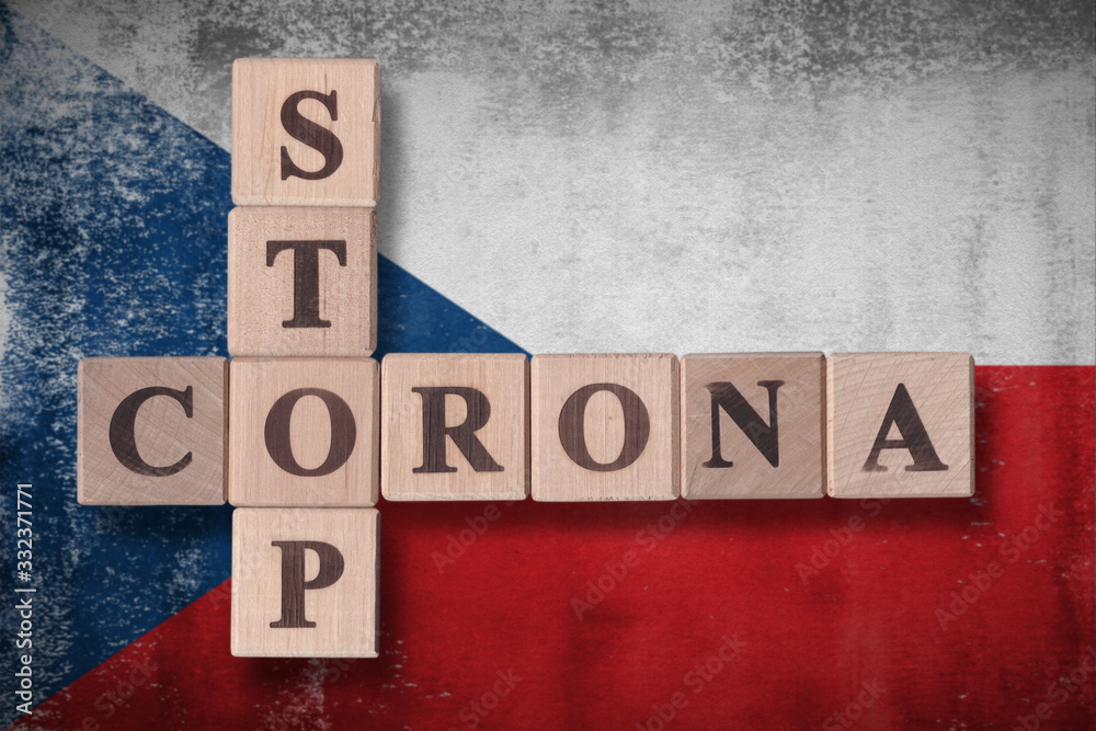 Fototapeta premium Flag of Czech Republic with wooden cubes spelling STOP CORONA on it. 2019 - 2020 Novel Coronavirus (2019-nCoV) concept art, for an outbreak occurs in Czech Republic.