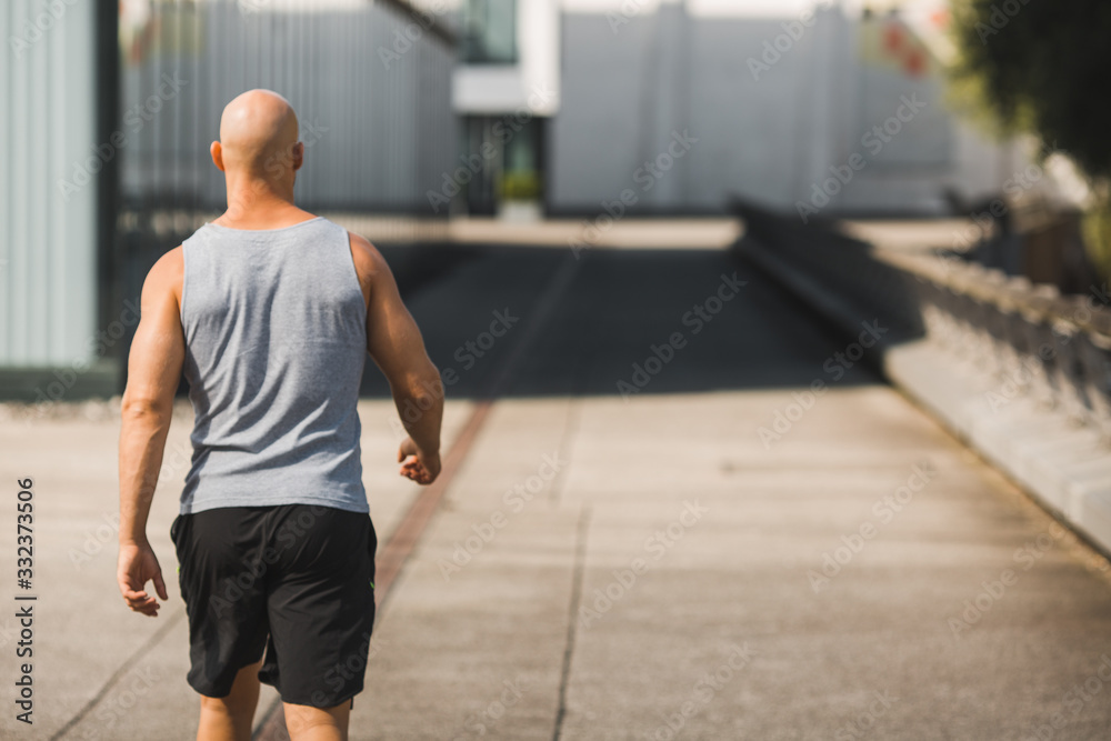 Muskulöser Mann geht allein seinen Weg in kurzen Hosen Muskulöser Mann geht allein seinen Weg in kurzen Hosen