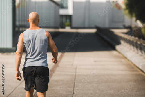 Muskulöser Mann geht allein seinen Weg in kurzen Hosen