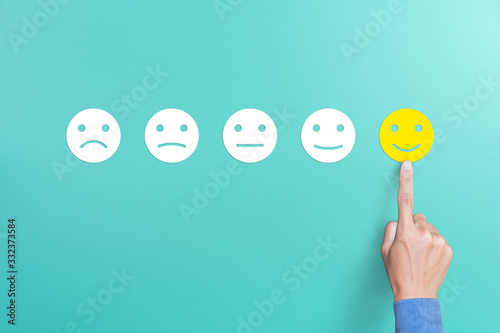 client's hand picked the happy face smile face, Customer service evaluation and satisfaction survey concept. copy space photo