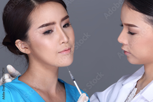 Beautician Doctor put syringe over Face structure patient before plastic surgery