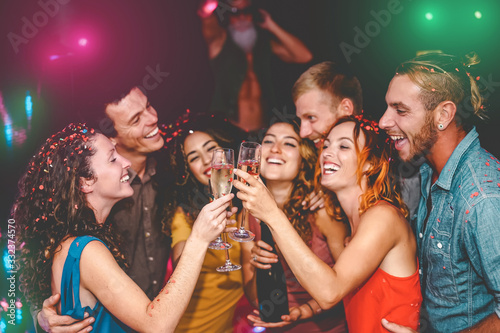 Happy friends celebrating new year eve holidays in disco club - Young people doing private party with deejay and drinking champagne - Youth culture entertainment lifestyle concept