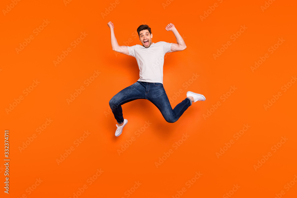Full size photo of crazy funny energetic delighted guy celebrate lucky lottery win jump raise fists scream yeah wear casual style clothes isolated over shine color background