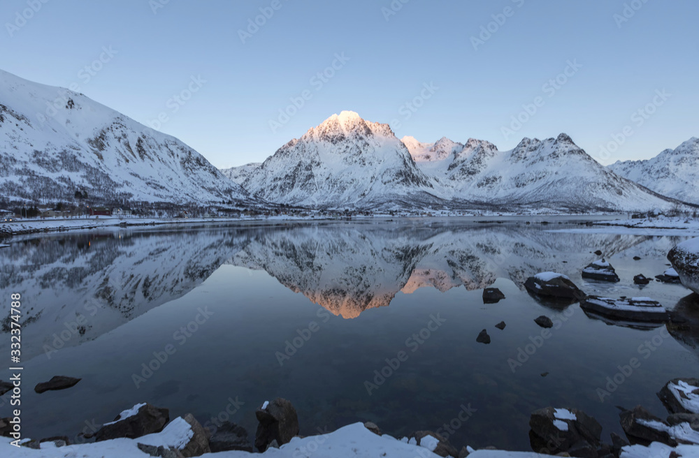snow mountain refelcted in lake Norway