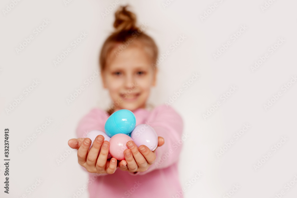 A girl holds colorful Easter eggs in her hands. Happy Easter, the concept of the Easter holiday A girl holds colorful Easter eggs in her hands. Happy Easter, the concept of the Easter holiday