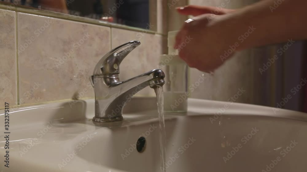 Close-up of a young man washing his hands thoroughly in the bathroom. Coronavirus pandemic prevention wash hands with soap warm water. Hand washing against germs and viruses. Close-up of a young man washing his hands thoroughly in the bathroom. Coronavirus pandemic prevention wash hands with soap warm water. Hand washing against germs and viruses.