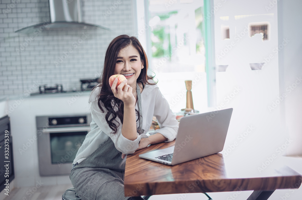 Portrait of beautiful young latin woman talking over the phone while cooking in kitchen Portrait of beautiful young latin woman talking over the phone while cooking in kitchen