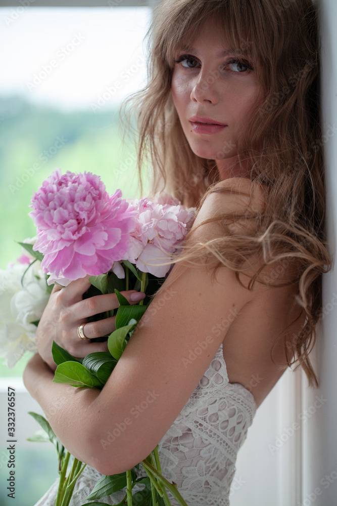Spring Woman. Beauty Summer model girl. Beautiful Lady with pink peony on her hand. Nature Hairstyle. Natural Makeup.