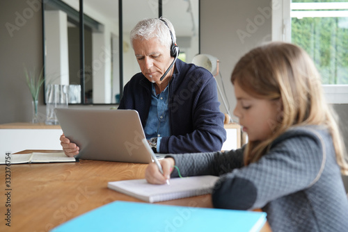Фотография Father and school-girl working form home, telework and e-learning
