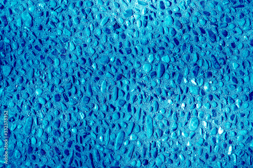 Abstract textured tinted classic blue color surface texture rough background, cement concrete floor or wall. The image is tinted in the color of the 2020 year-classic blue.