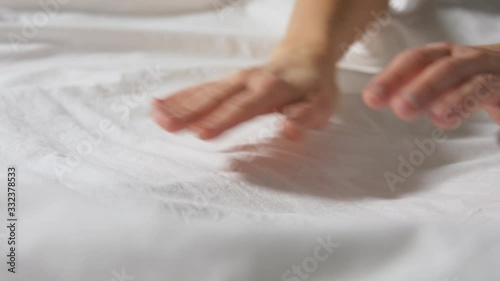 household, housework and cleaning concept - hands of woman making bed linen photo
