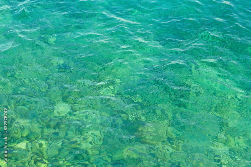 Blue green transparent lake water texture. Background of tranquil water. Summer vacation concept.