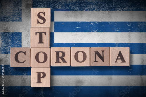 Flag of Greece with wooden cubes spelling STOP CORONA on it. 2019 - 2020 Novel Coronavirus (2019-nCoV) concept art, for an outbreak occurs in Greece.