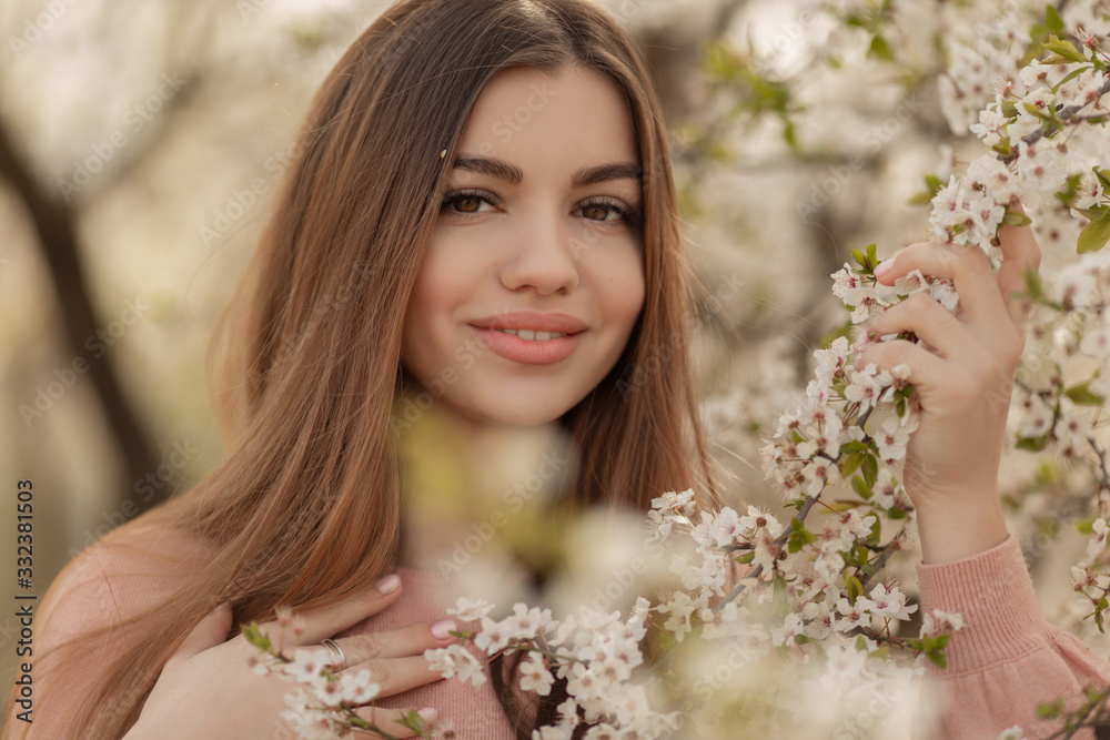 Portrait of pretty young girl in the garden of blossom cherry trees. Spring time Portrait of pretty young girl in the garden of blossom cherry trees. Spring time
