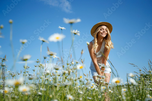 Woman in a field with flowers. A young and beautiful girl is resting in a chamomile field.