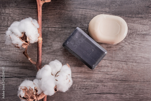 Soap and cotton on a structural background, the concept of cleanliness, tenderness, care, health and personal hygiene. Protection against infections and coronovirus