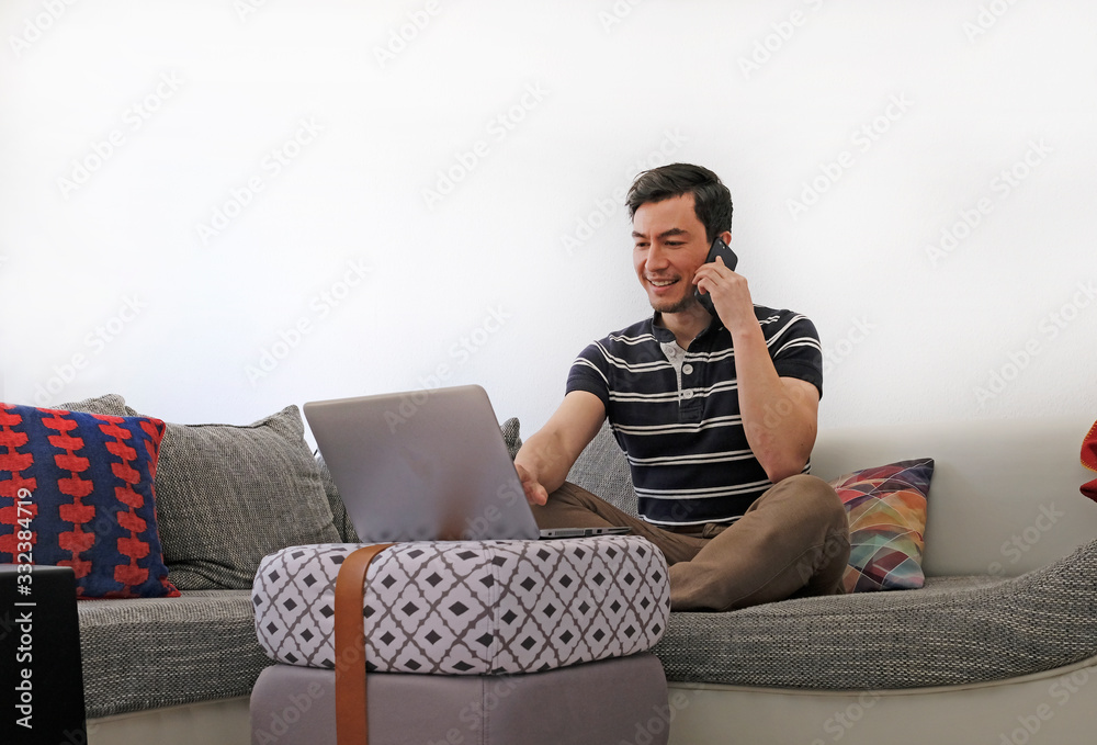 Obraz premium Man working from home with a laptop in the living room