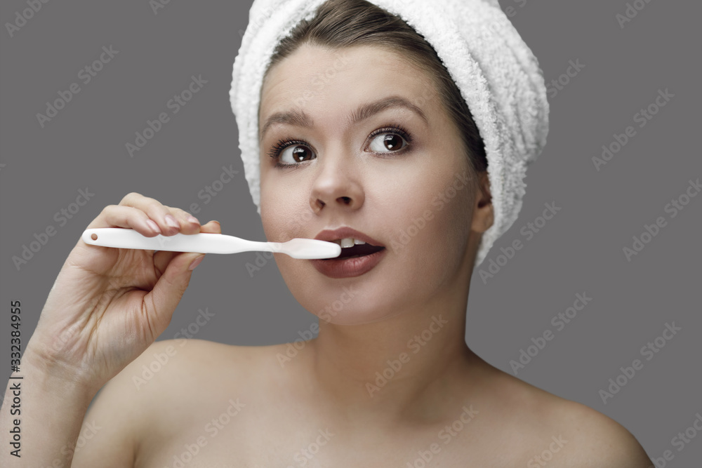 girl with a white toothbrush in a towel