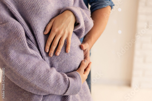 Beautiful pregnancy of young family. Pregnant woman and man. Happy couple, wife and husband hugging tummy photo