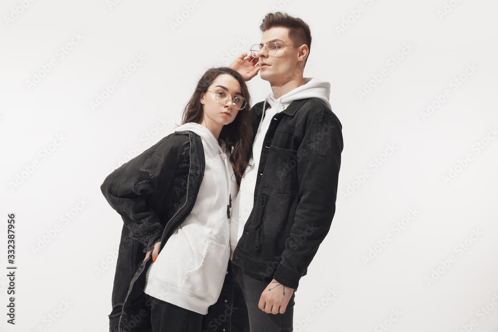 In black. Trendy fashionable couple isolated on white studio background. Caucasian woman and man posing in basic minimal unisex clothes. Concept of relations, fashion, beauty, love. Inclusive. In black. Trendy fashionable couple isolated on white studio background. Caucasian woman and man posing in basic minimal unisex clothes. Concept of relations, fashion, beauty, love. Inclusive.