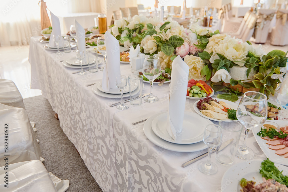 Table set with plates, white serviettes and cutlery on table, copy space. Place setting at wedding reception. Table served for wedding banquet in restaurant Table set with plates, white serviettes and cutlery on table, copy space. Place setting at wedding reception. Table served for wedding banquet in restaurant