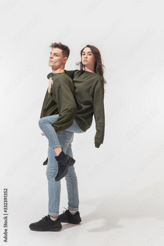 Supporting. Trendy fashionable couple isolated on white studio background. Caucasian woman and man posing in basic minimal unisex clothes. Concept of relations, fashion, beauty, love. Inclusive. Supporting. Trendy fashionable couple isolated on white studio background. Caucasian woman and man posing in basic minimal unisex clothes. Concept of relations, fashion, beauty, love. Inclusive.