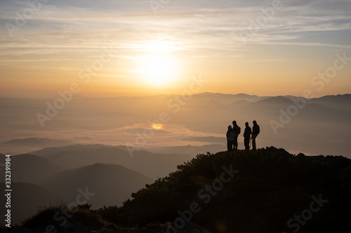 people standing at the hill during sunrise