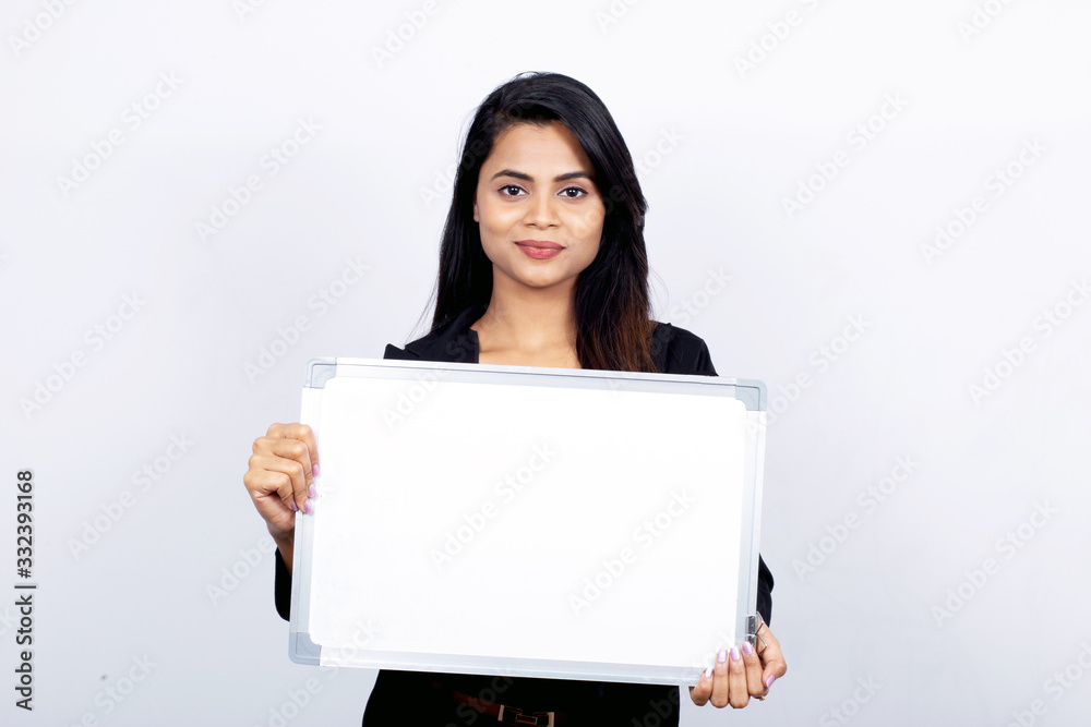 Portrait of confident Indian businesswoman showing blank signboard for copy space Portrait of confident Indian businesswoman showing blank signboard for copy space