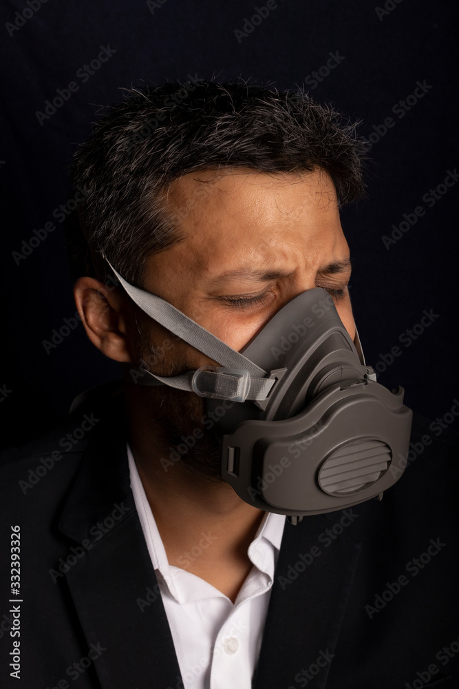 Young handsome with fear and industrial mask to prevent the spread of contagious viruses or chemical gases Young handsome with fear and industrial mask to prevent the spread of contagious viruses or chemical gases