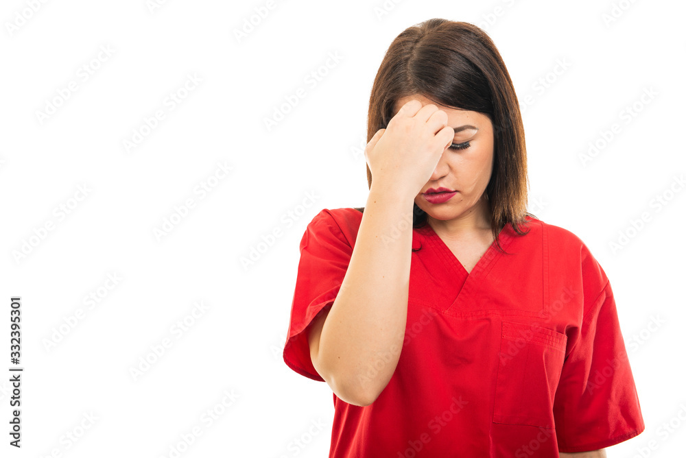 Portrait of beautiful young doctor wearing scrubs making headache gesture Portrait of beautiful young doctor wearing scrubs making headache gesture