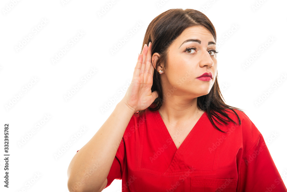 Portrait of doctor wearing scrubs making can't hear gesture Portrait of doctor wearing scrubs making can't hear gesture