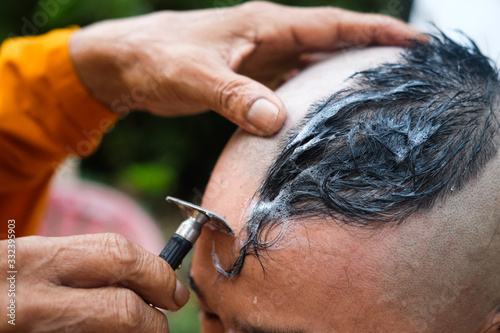 Close up shot of shaved hair for ordained Buddhist man.