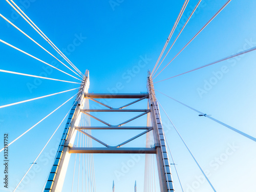 Pylons with steel ropes of the cable-stayed bridge agains clear blue sky. Detail of the multi-span bridge in Saint Petersburg, Russia. 