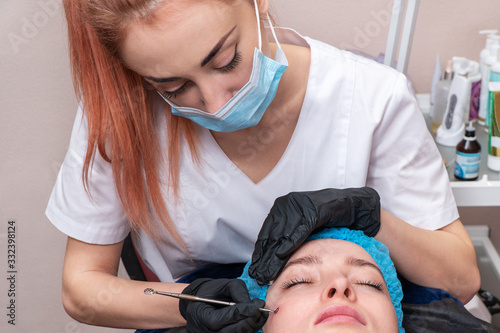 beautician cleans the patient face