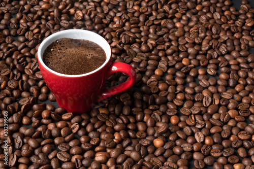 coffee in a red cup on a background of coffee beans