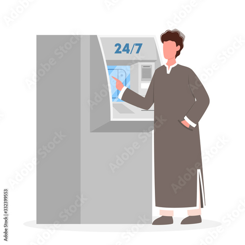 ATM. Muslim man standing nearby an ATM. Bank machine,