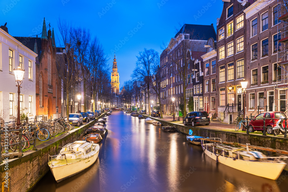 Amsterdam, Netherlands canals and church tower at dusk.
