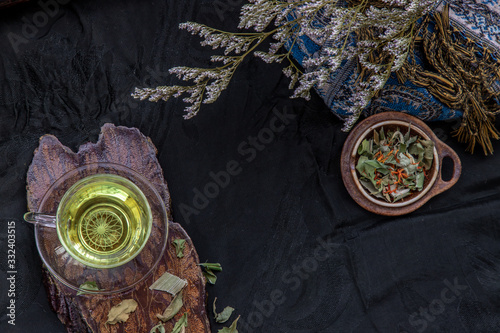 A Cup of pandan leaf tea, indian marsh fleabane plant leaves with Safflower dried (Saffron substitute) at dark background. photo