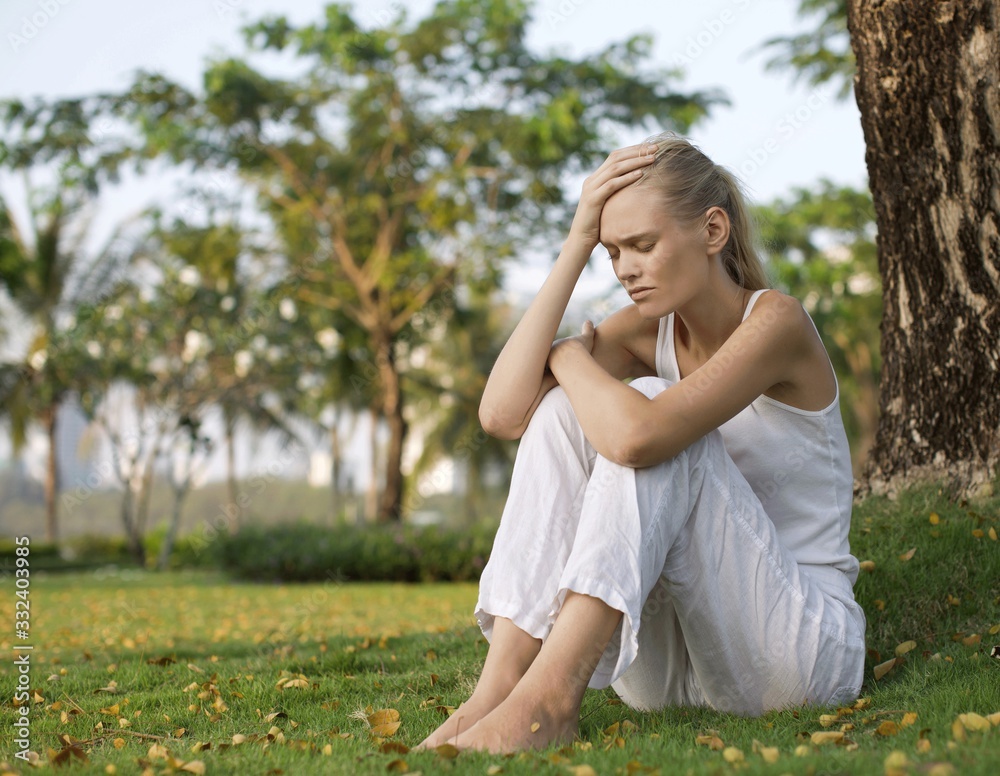Depressed woman sitting outside. Unhappy girl in park. Depressed woman sitting outside. Unhappy girl in park.