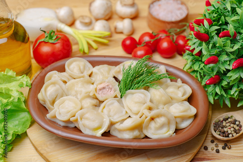 Dumplings on a wooden board with meat and vegetables