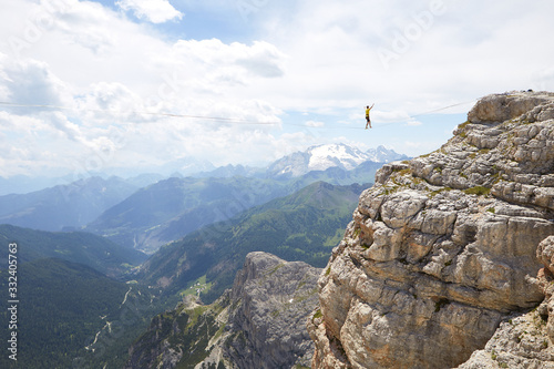 tightrope walker on a mountain with blue sky and clouds
