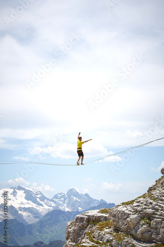 tightrope walker on a mountain with blue sky and clouds © francesca
