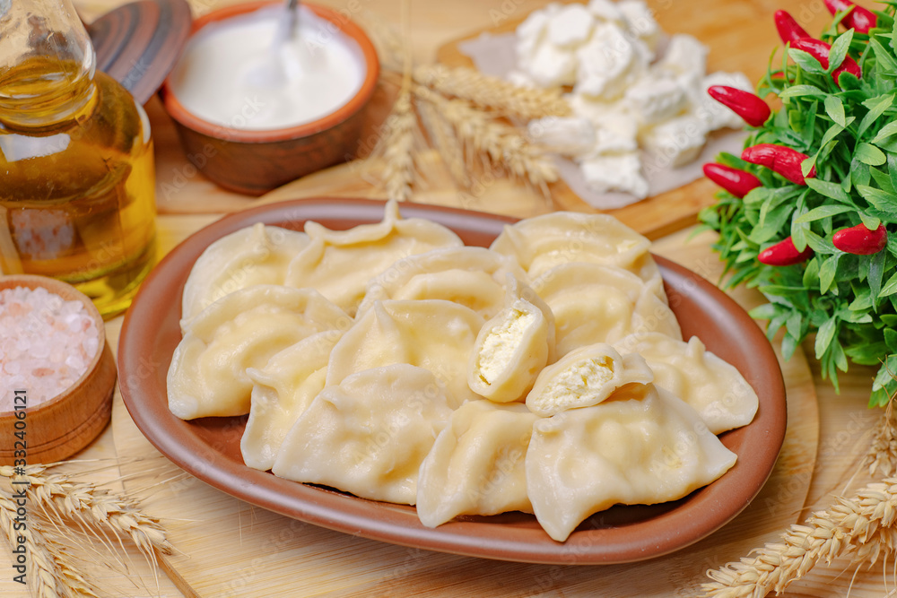 Dumplings on a wooden board with vegetables and cottage cheese Dumplings on a wooden board with vegetables and cottage cheese