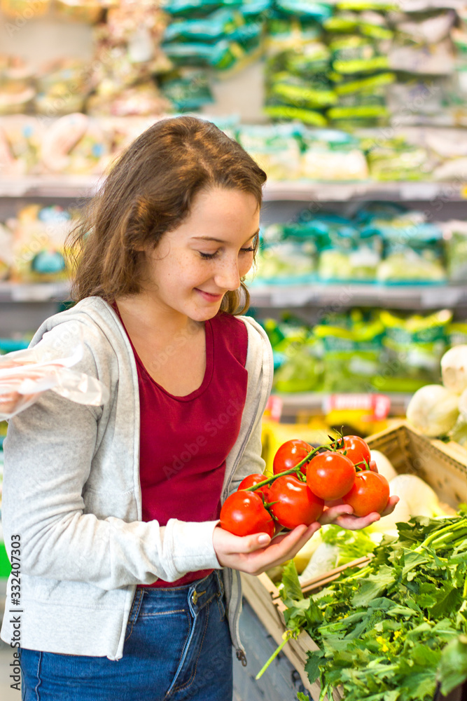 Teen girl shopping at the supermarket. Young people make the conscious, organic and healthy choice.