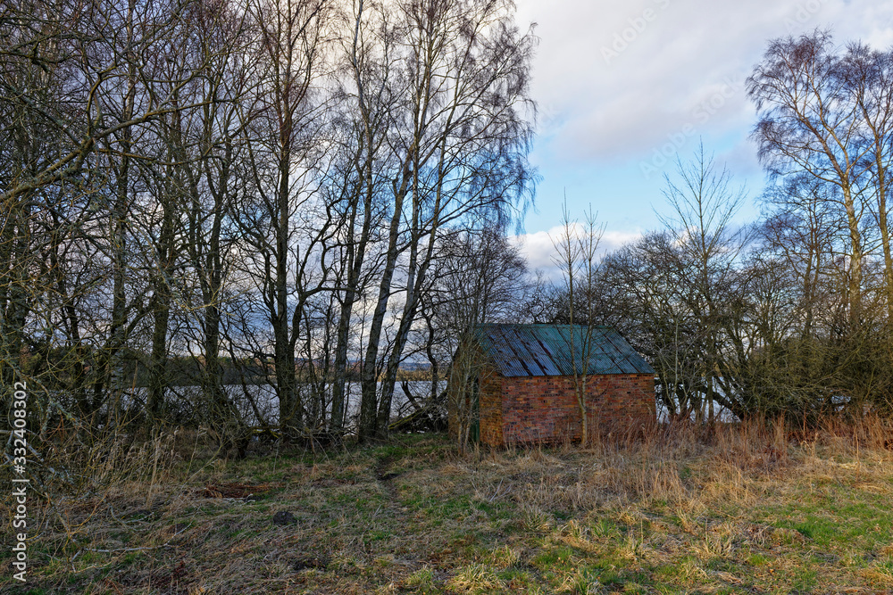 A small Disused and empty Boat house hidden in the undergrowth on the side of Stormont Loch in Perthshire on a cold March Evening. A small Disused and empty Boat house hidden in the undergrowth on the side of Stormont Loch in Perthshire on a cold March Evening.