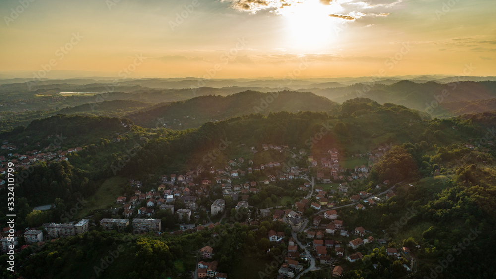 Fototapeta premium Aerial view of downtown Tuzla at sunset, Bosnia. City photographed by drone, traffic and objects , landscape.city photographed from air by drone.Old balkan buildings and communism type of architecture